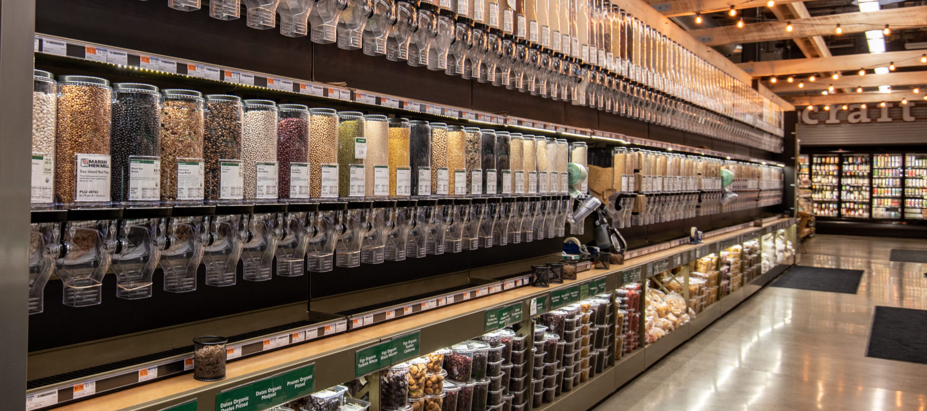 A photo of a store aisle with gravity bins lining the wall.