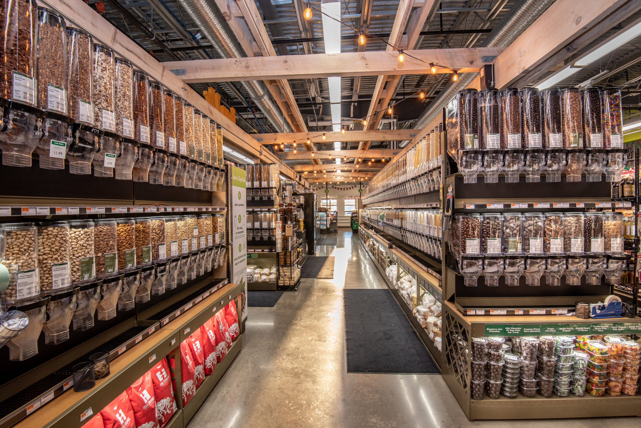 A photo of a store aisle with gravity bins lining the wall.