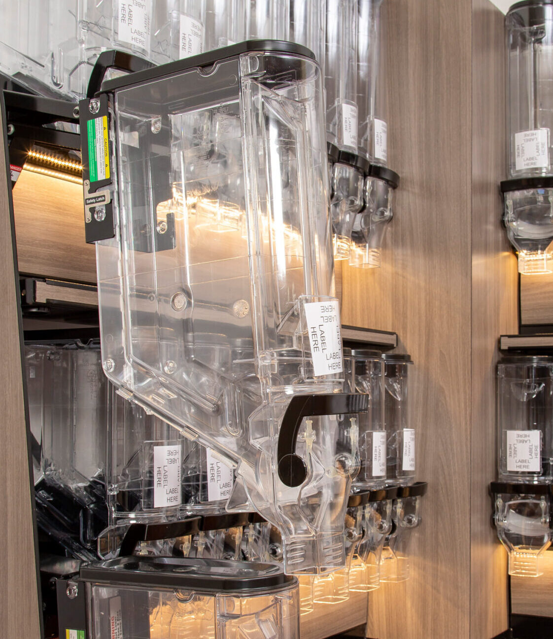 A photo of a store wall with a variety of empty gravity bins.