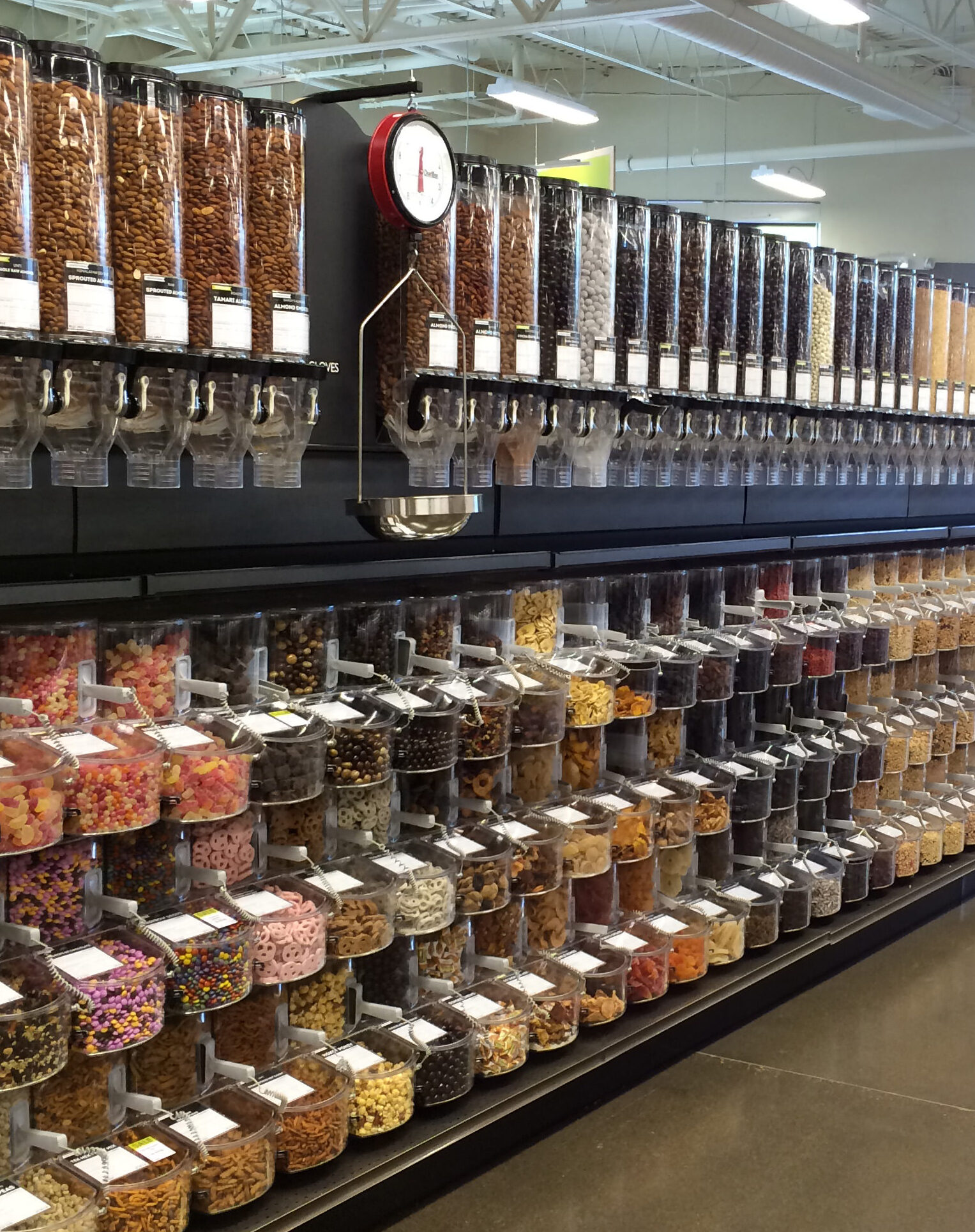 A photo of a store aisle with gravity bins lining the wall.