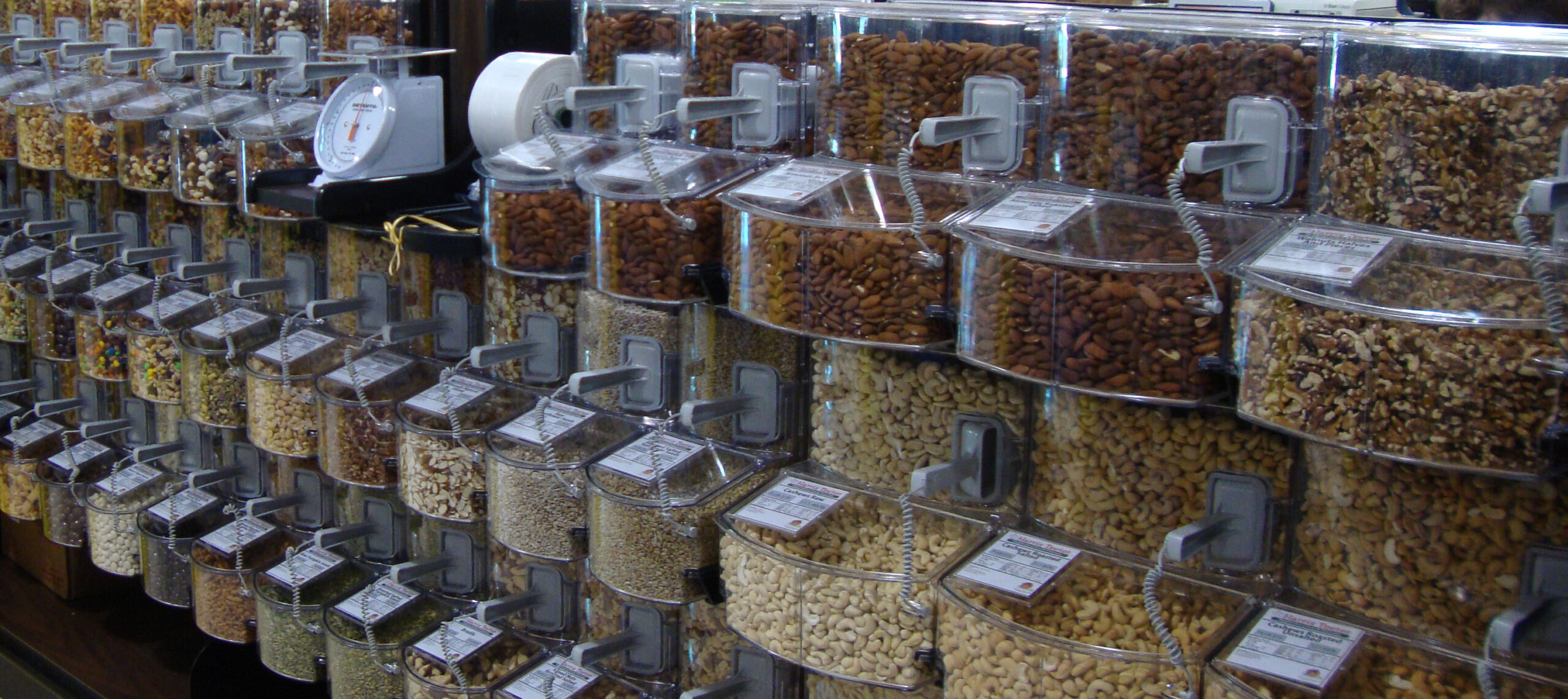 A photo of a store aisle with nut filled gravity bins.